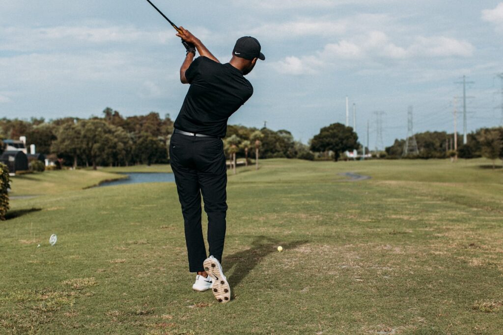 Golfer making a powerful swing on a sunny day