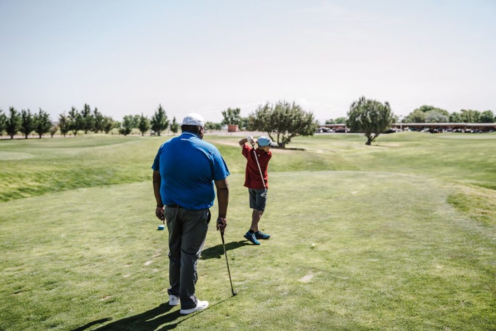 Golf coach working with student on the course